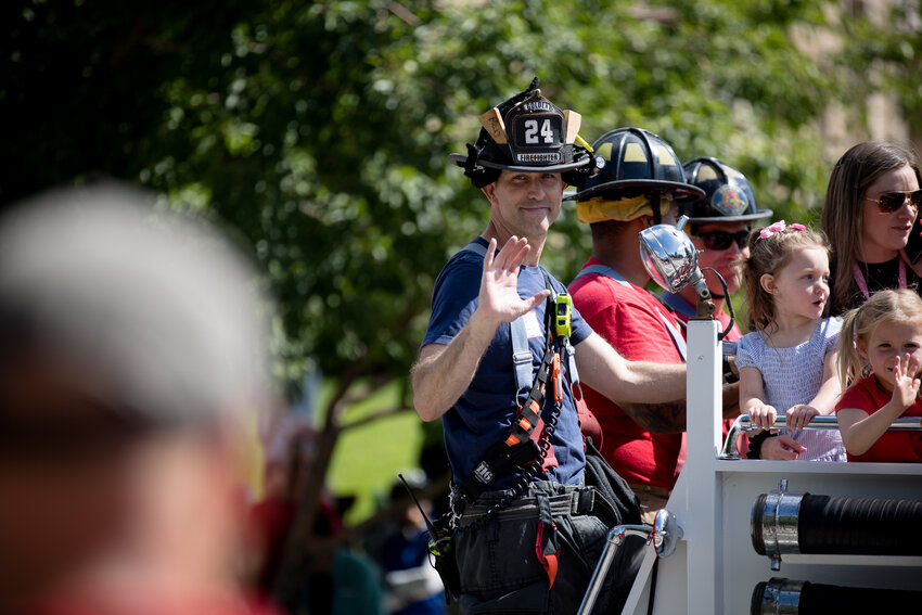 Members of the Golden Fire Department wave to people as they drive down the parade route Saturday morning.